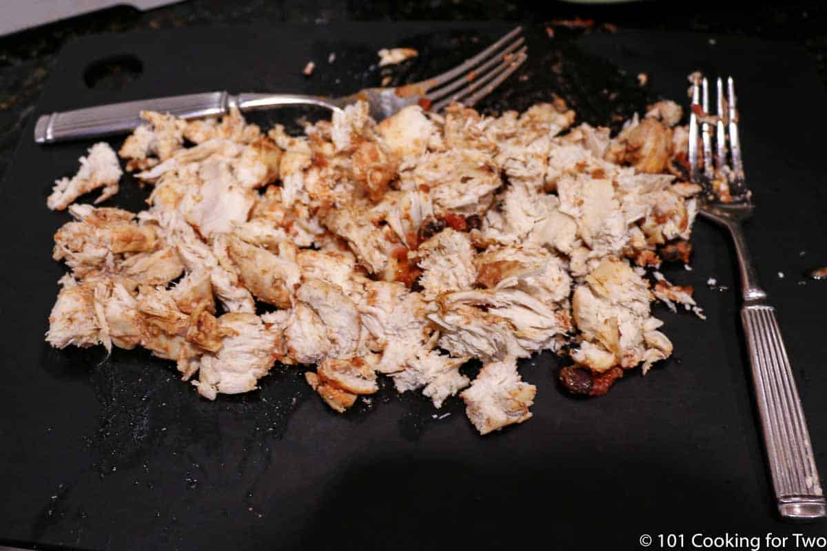 shredded chicken on a black board.