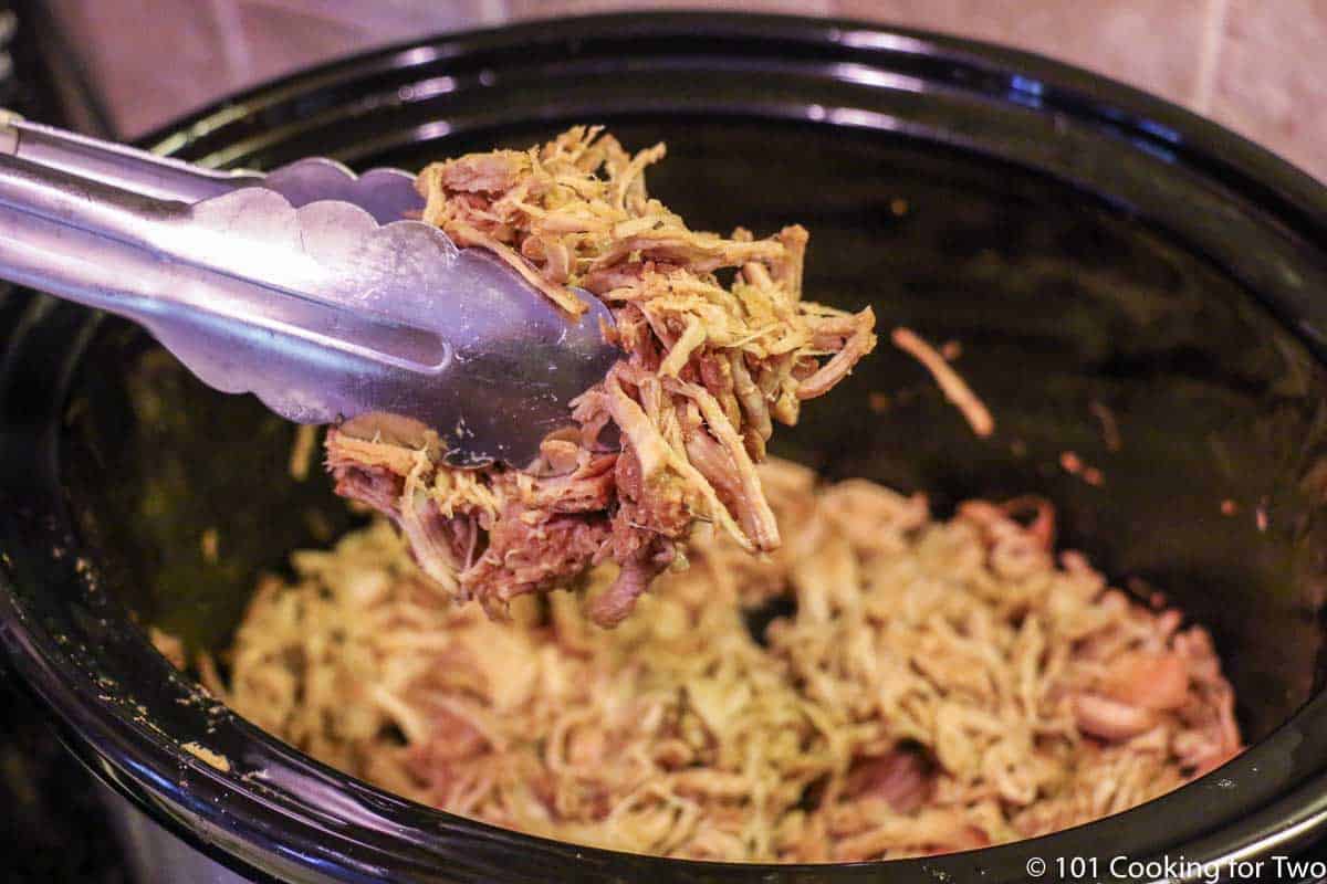 shredded pork in tongs