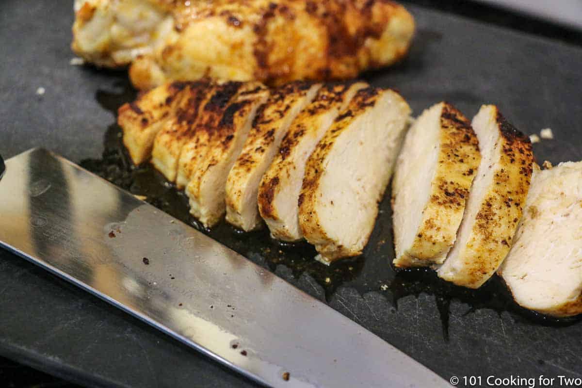 sliced chipotle chicken on a black board.