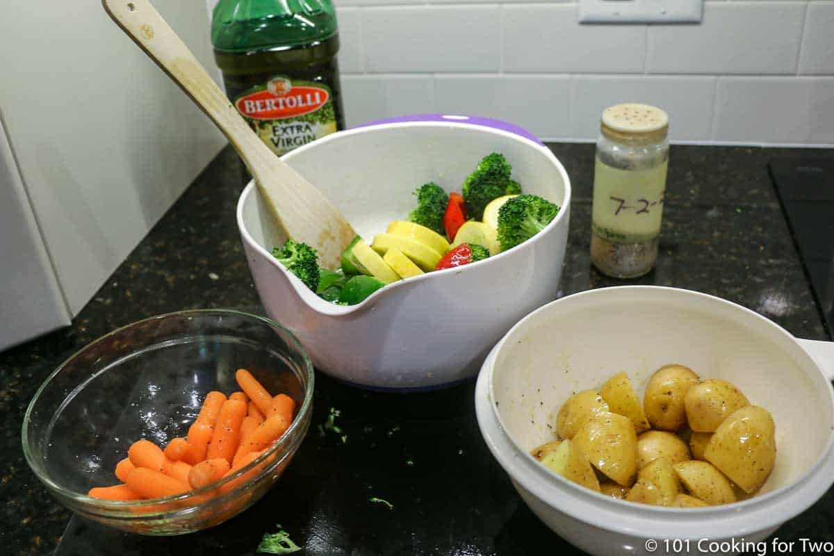 three bowls of prepared vegetable with oil.