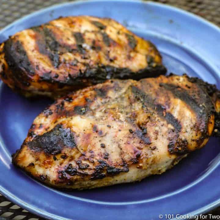 two grilled chicken breasts on a blue plate