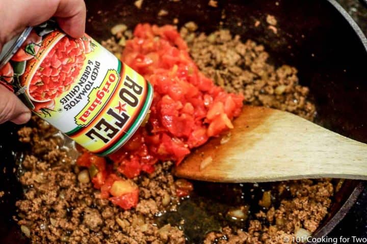 adding RoTel to pan of cooked burger