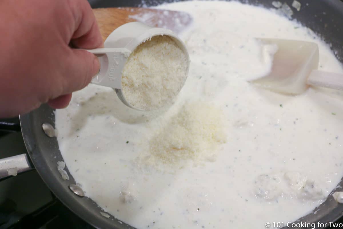 adding cheese to sauce in pan
