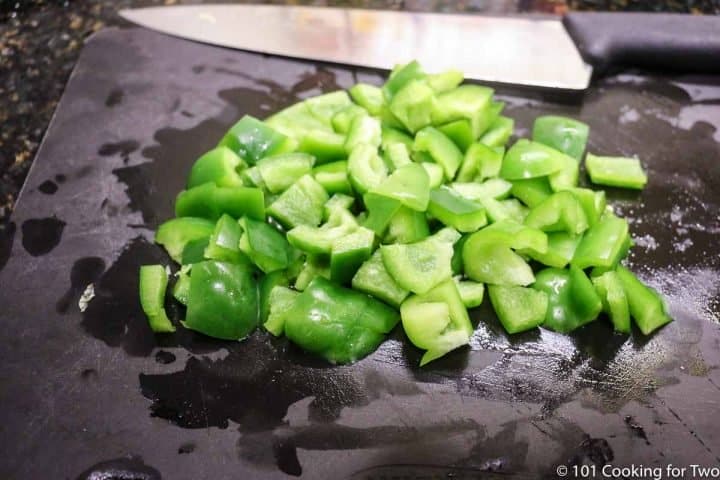 chopped green pepper on a black board