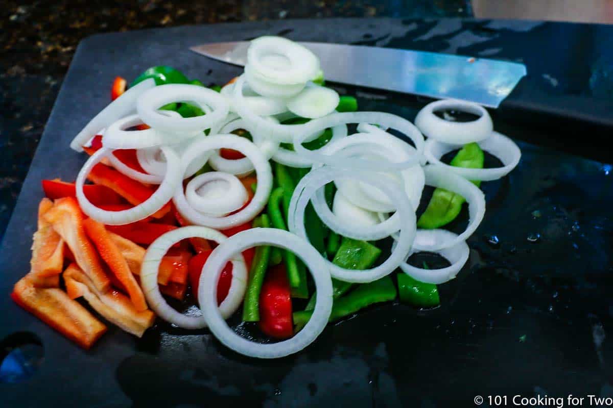cut up peppers and onions on black board