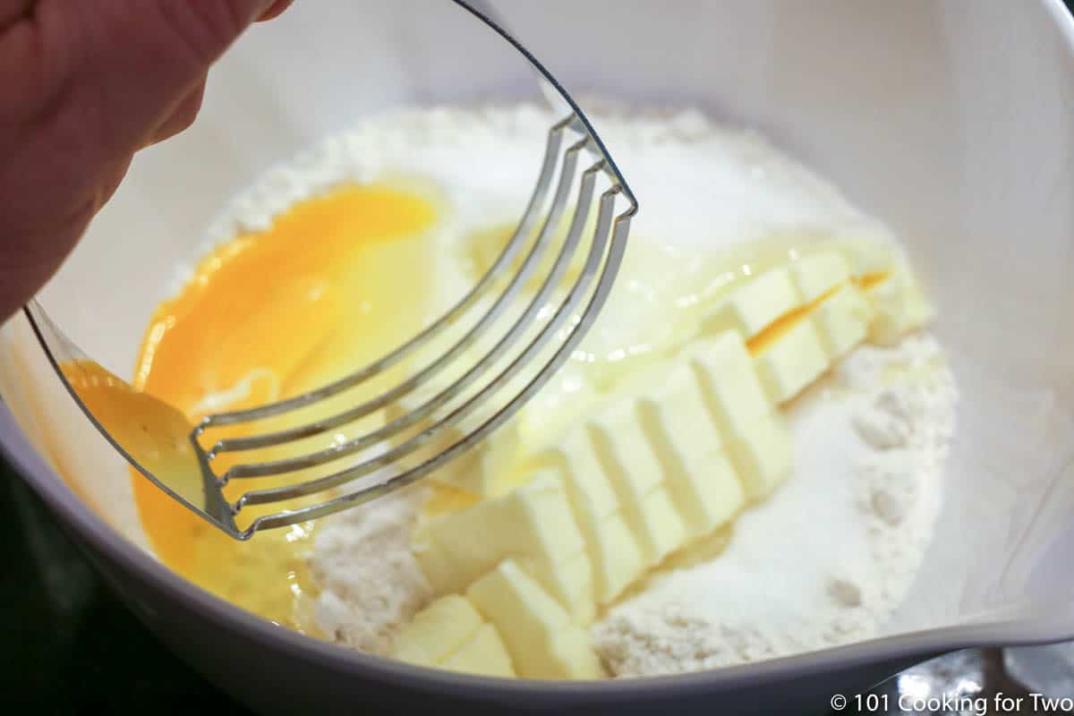 cutting butter into crust ingredients in white bowl