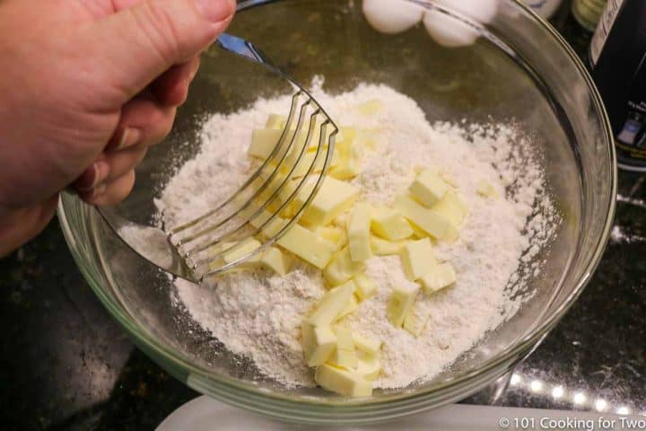 cutting butter into flour with pie cutter in clear bowl
