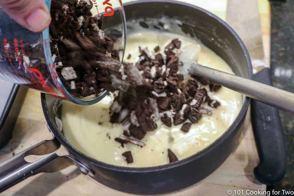 mixing chopped oreos into melted fudge.