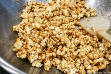 mixing coating into popcorn with spatula