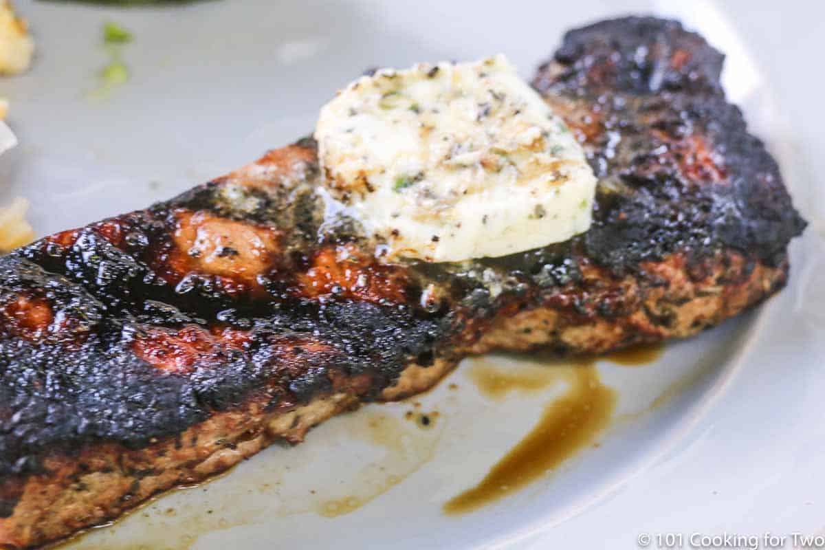 pat of compound butter on grilled strip steak.