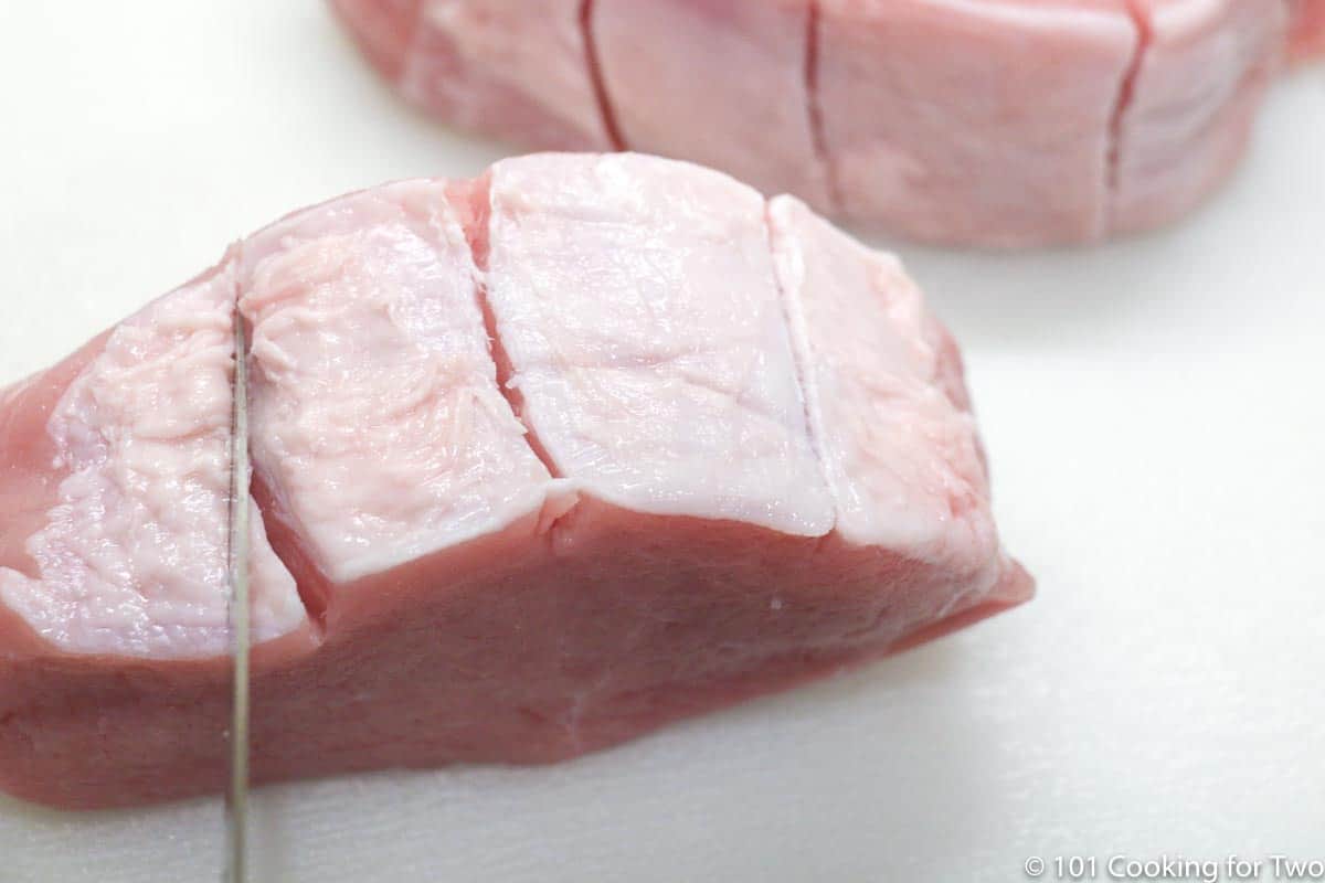 slicing the fat rim in the pork chop