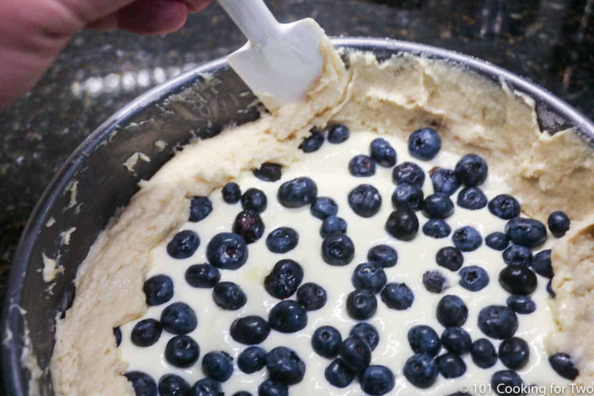 using a spatula to fold the crust over the edge of the filling.