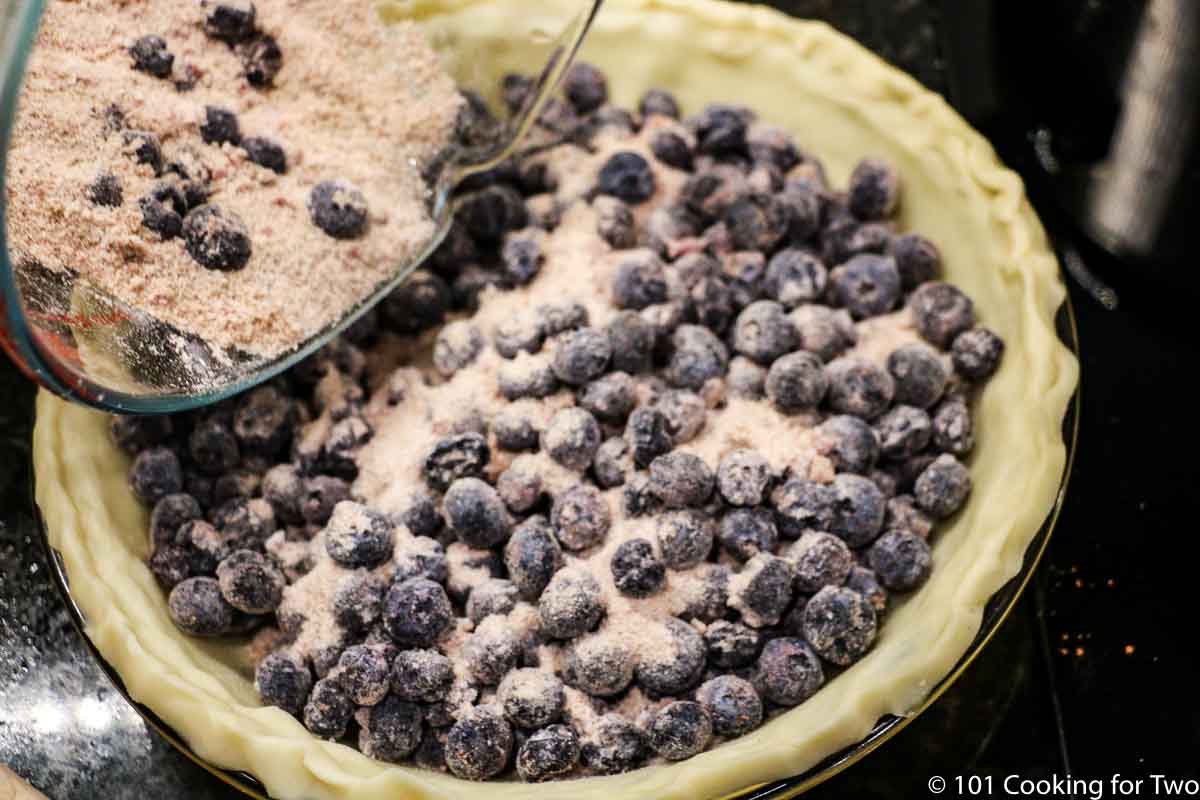 adding blueberry filling to crust.