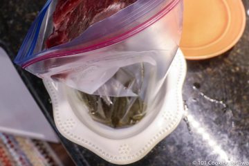 adding flank steak to bag with marinade