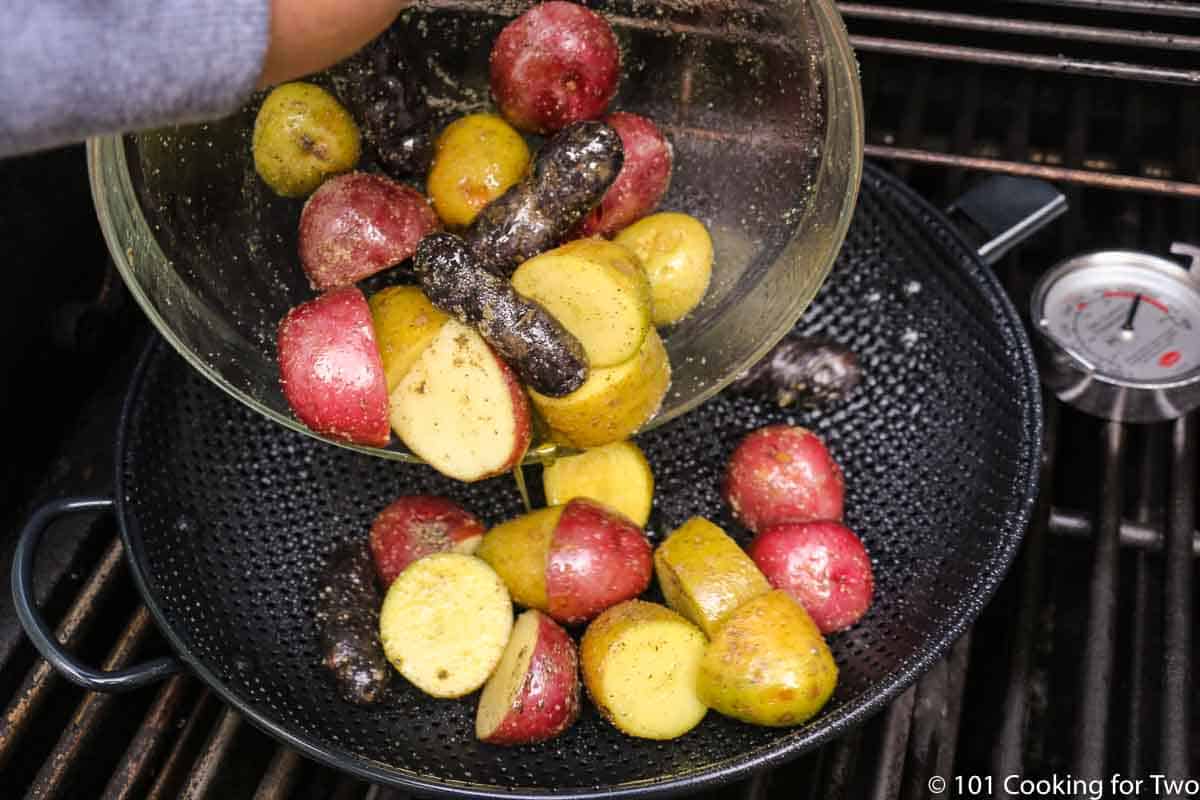 adding potatoes to grill pan over direct heat.