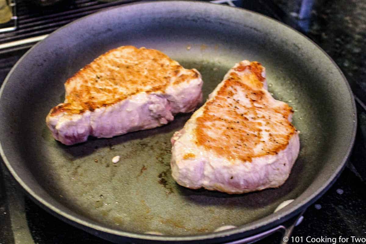 browning pork chops in fry pan.