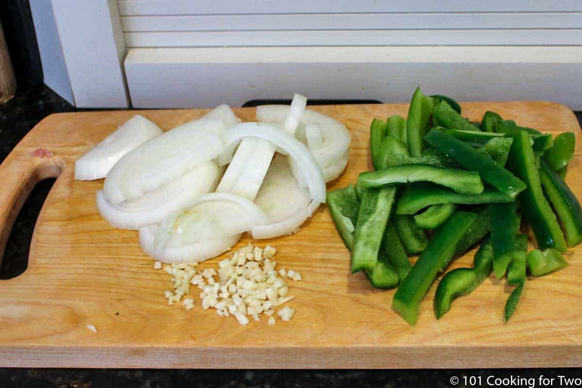 chopped onion and pepper on wooden board.