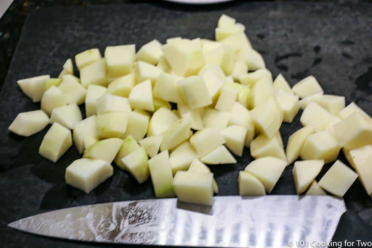 chopped potatoes on black board.