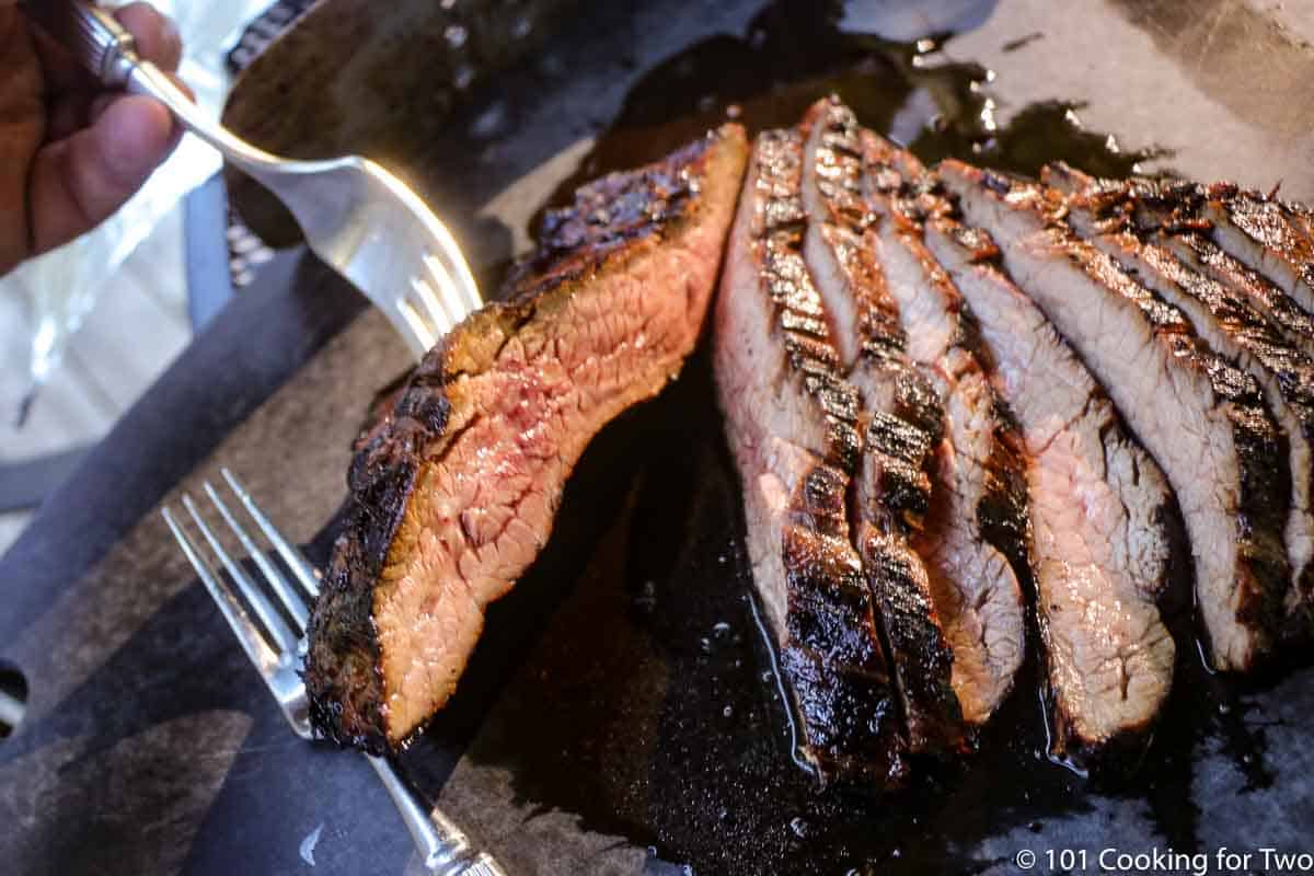 cut flank steak on black board.