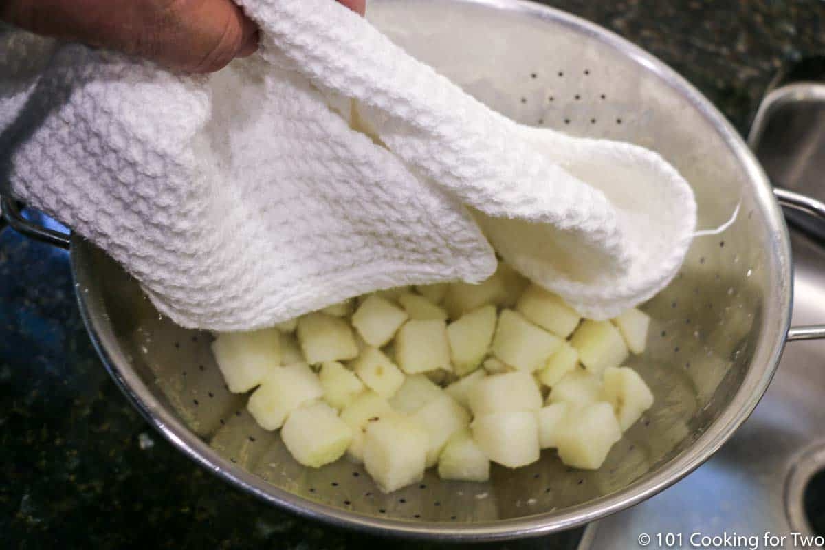 draining the cooked potato and drying with a white towel