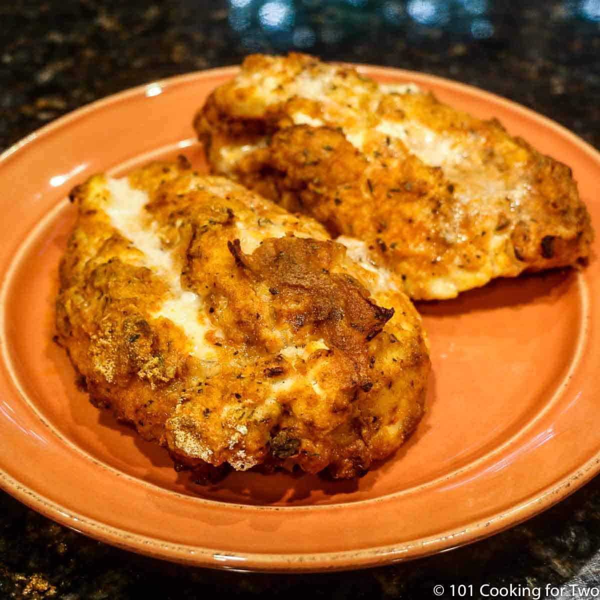 fried chicken breasts on orange plate.