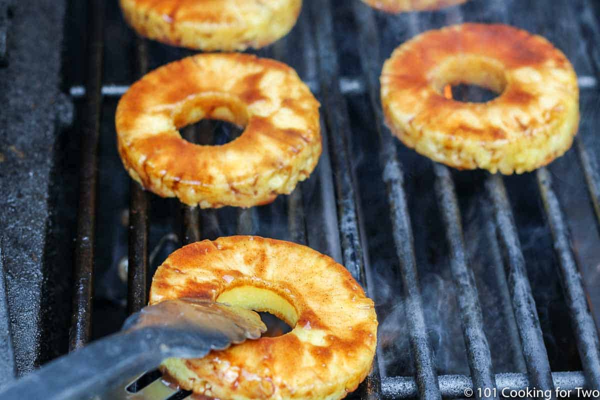 placing pineapple rings on grill