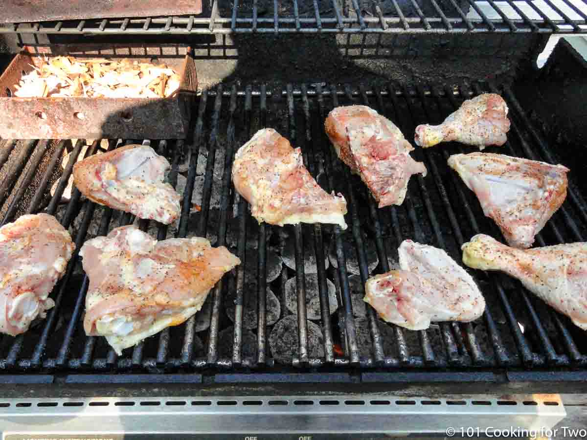 raw chicken on grates of gas grill