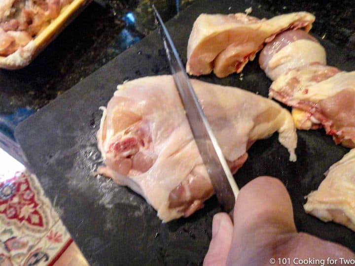 split chicken breast with knife of black board