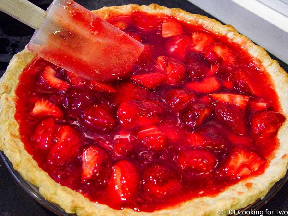 spreading strawberries and coating into pie crust
