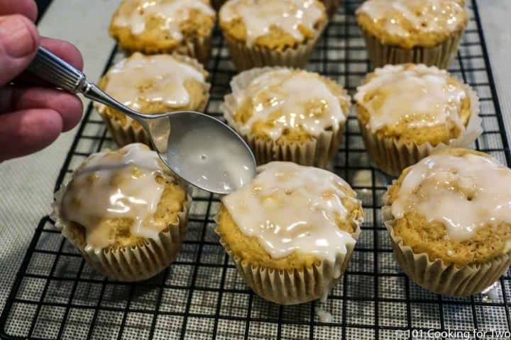 adding glaze to muffins with a spoon