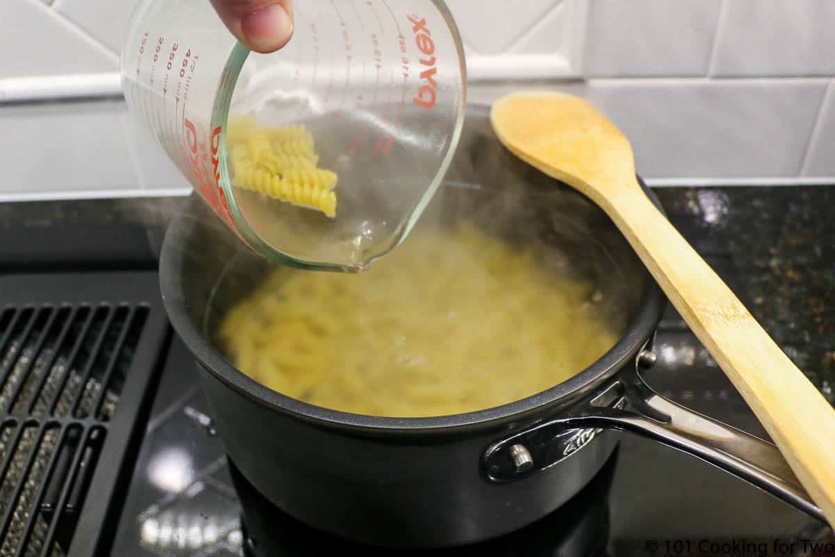 adding pasta to boiling water