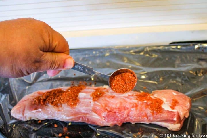 adding rub to the tenderloin with a spoon