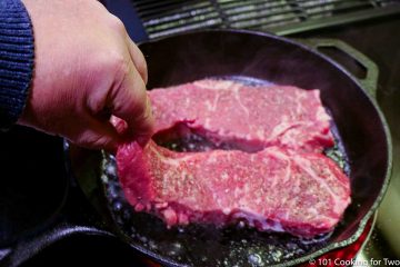 adding steaks to hot skillet