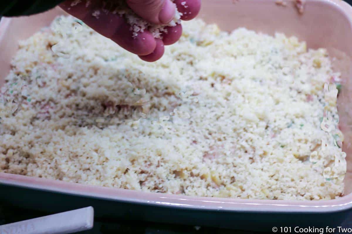 adding topping to casserole.