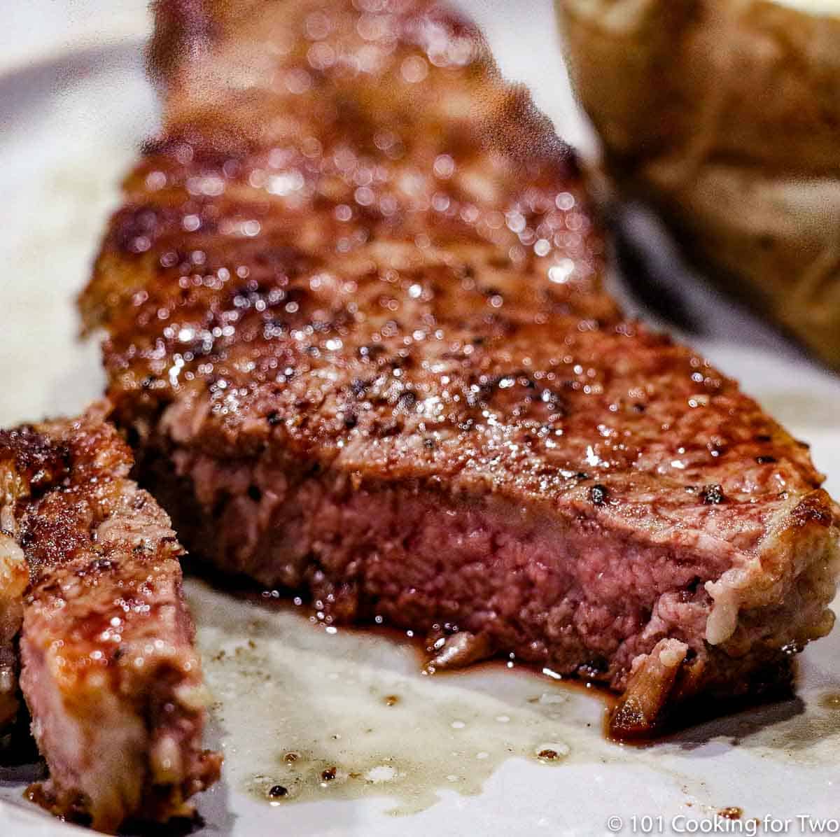 cut strip steak on gray plate