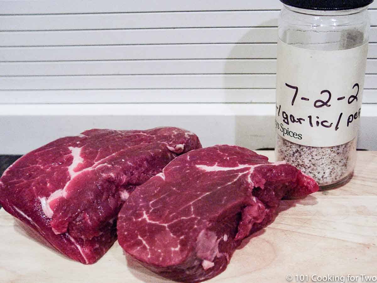 filets on wooden board with seasoning