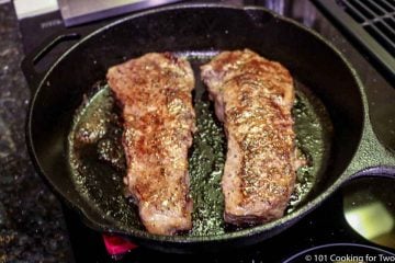 finished steaks in a black skillet