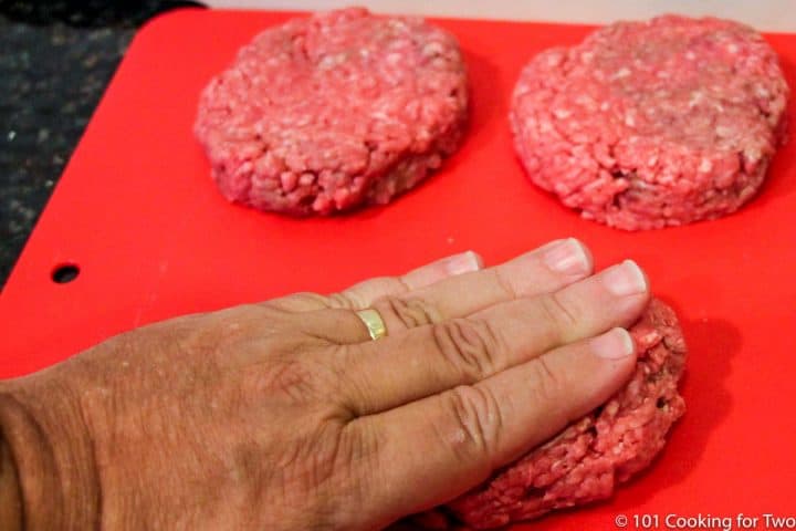 forming burgers into patties on red board