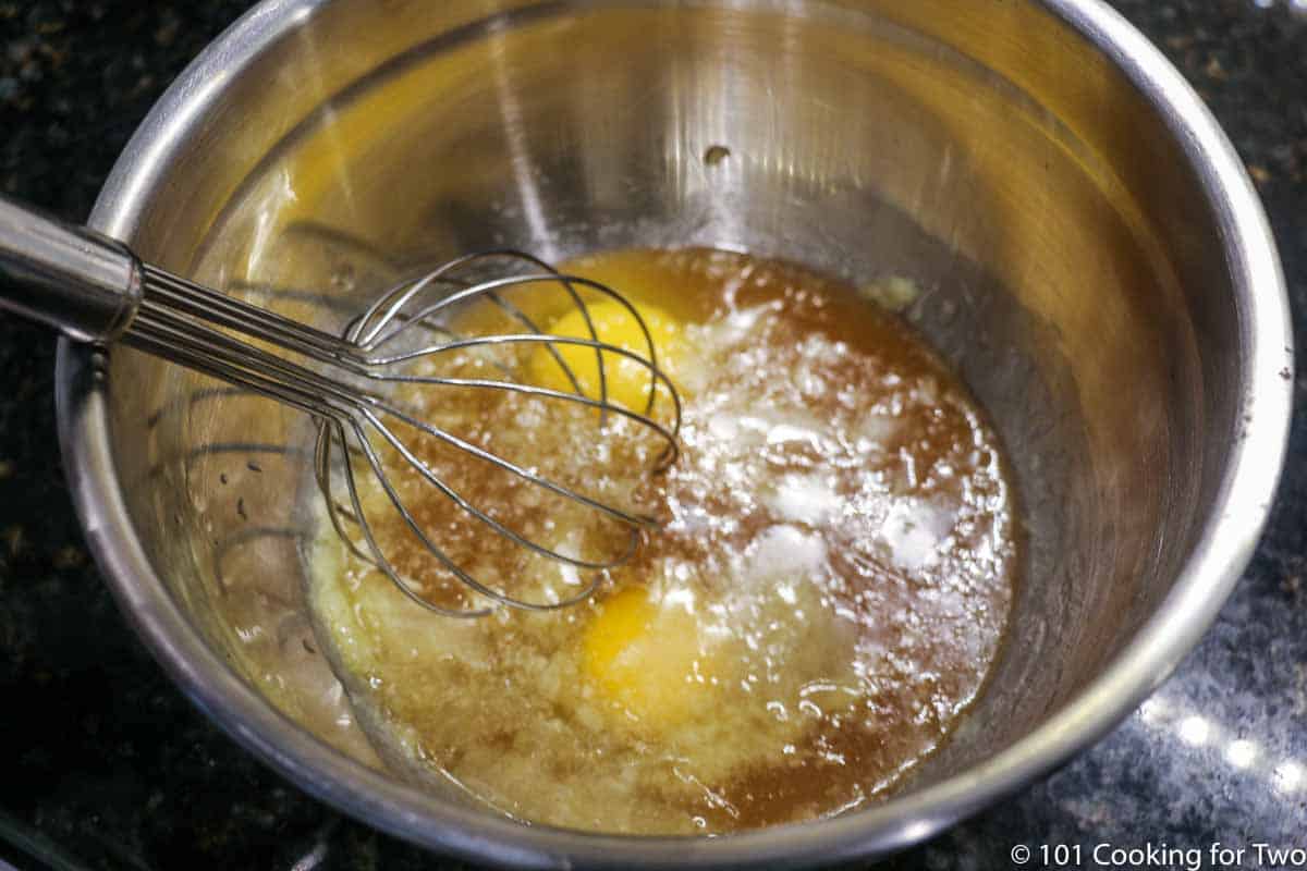 mixing eggs and wet ingredients in metal bowl.