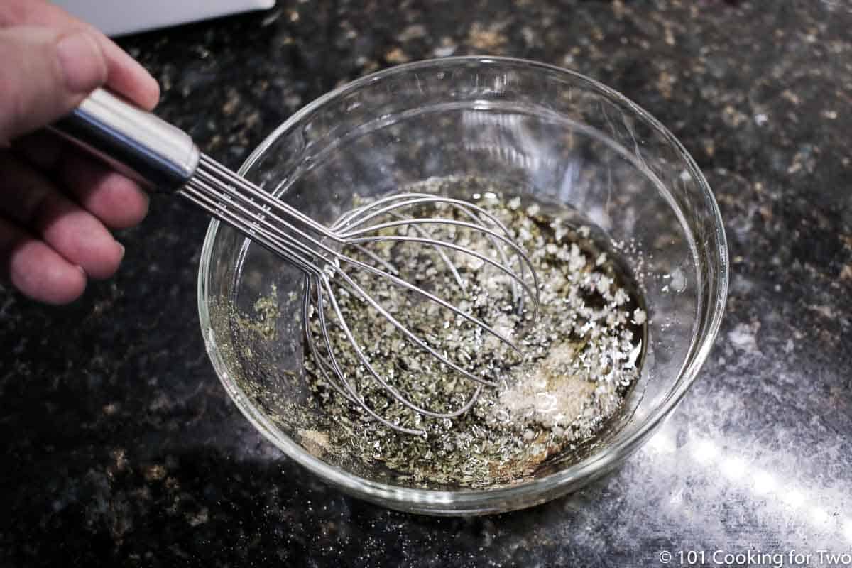 mixing marinade in bowl with whisk.