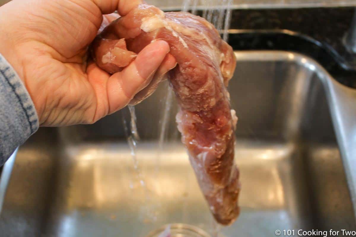 rinsing the tenderloin under running water