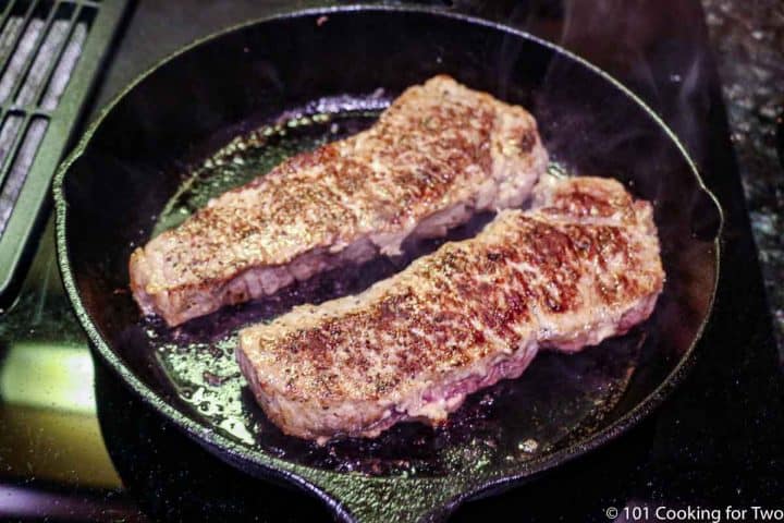 seared steaks in a black skillet