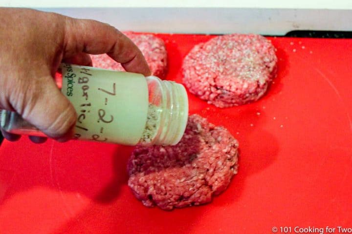 seasoning burgers with salt and pepper