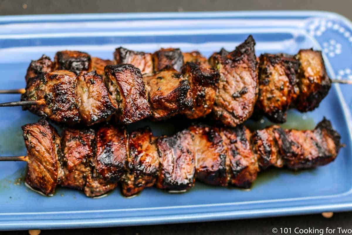 steak kabobs on blue plate.