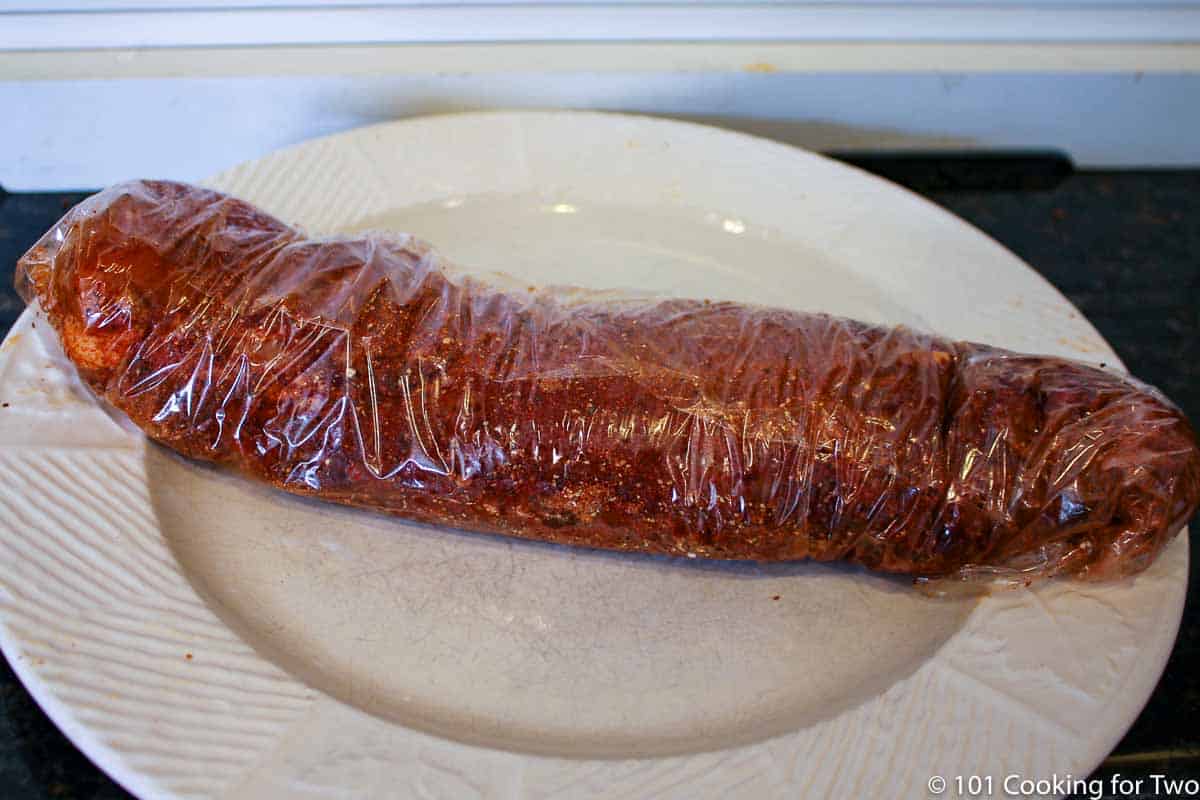 tenderloin with rub wrapped tightly in plastic wrap