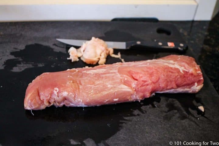 trimmed pork tenderloin on black board