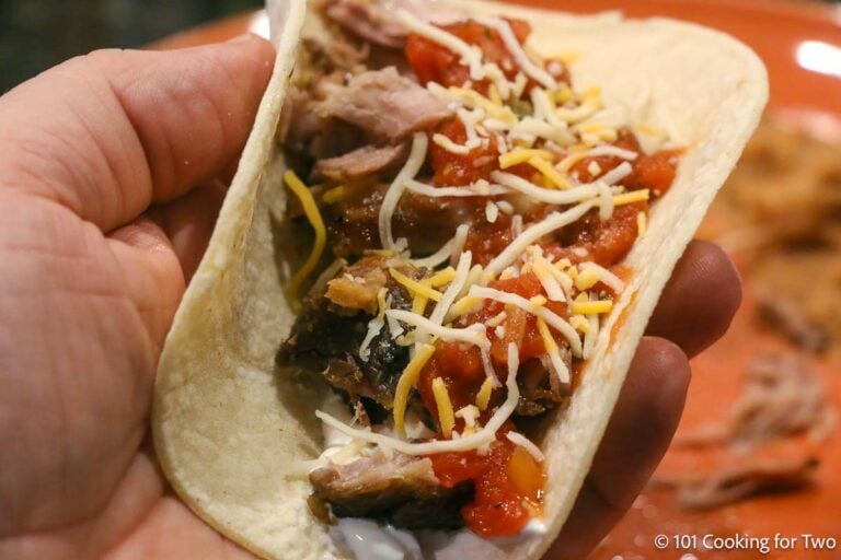 Shredded carnitas with toppings for a taco.