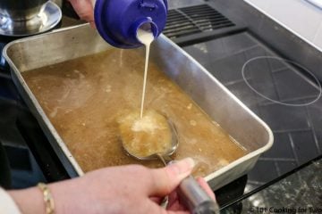 adding flour mixture to pan on stove making gravy