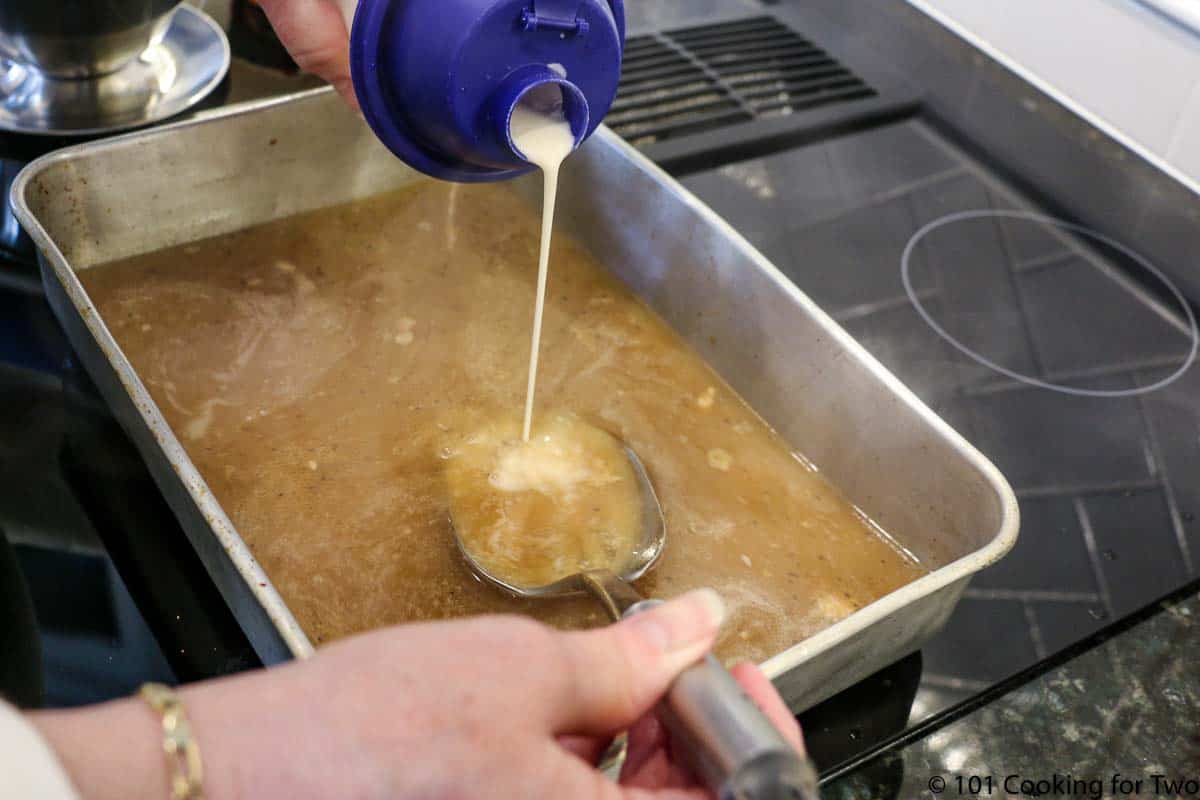 adding flour mixture to pan on stove making gravy.