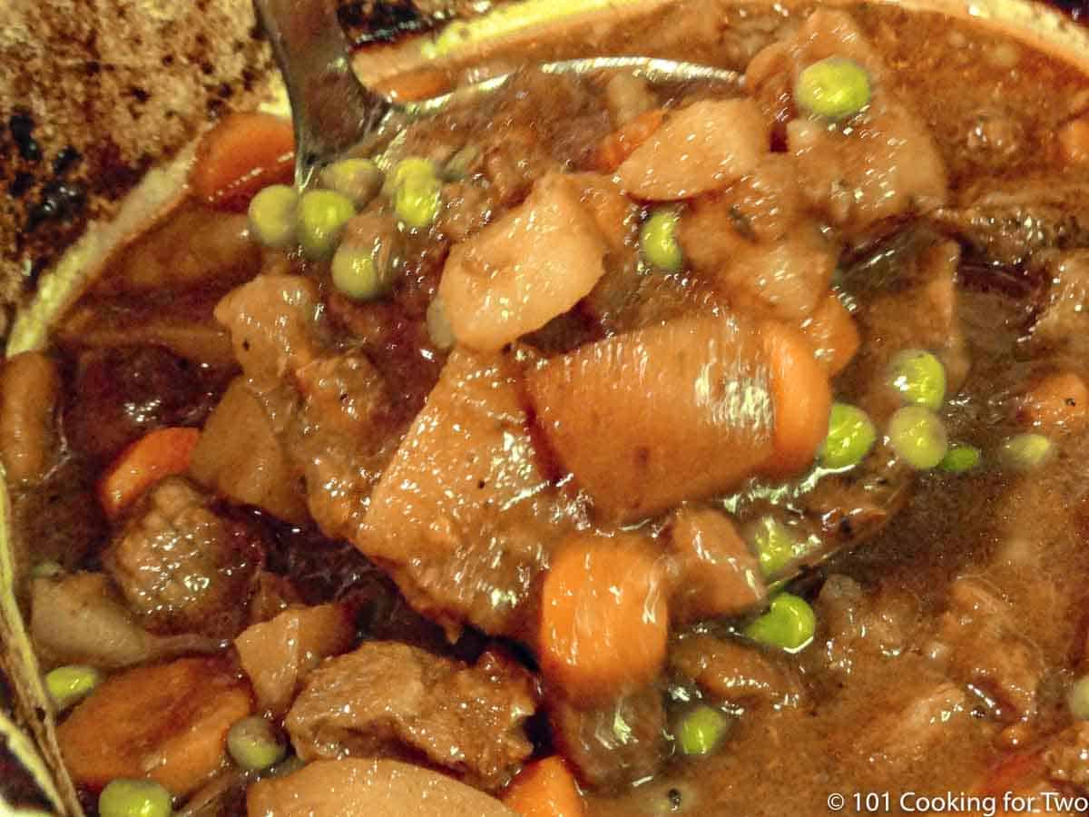 ladel of stew over crock pot